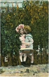 zwei kinder vor einer hecke