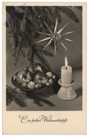 Kerze mit einer Schale Nüsse