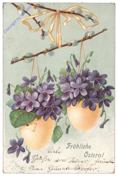 Eier hängen auf einem Zweig mit Veilchen