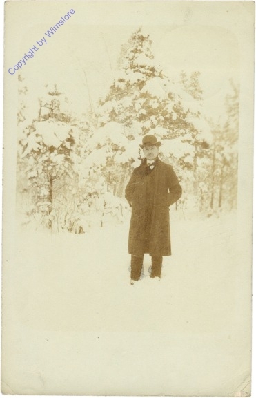 Mann stehend vor einem Winterwald